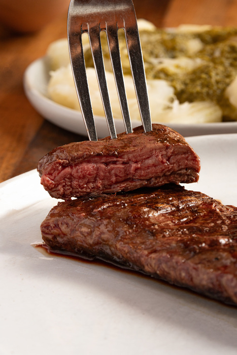 Image of a fork holding a piece of meat