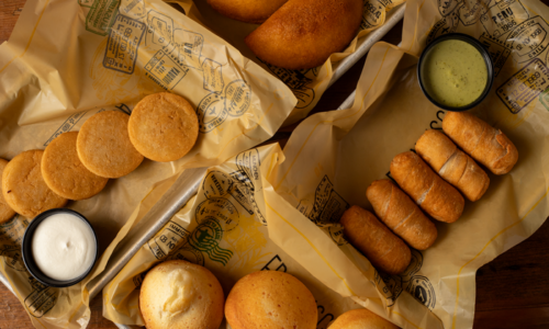Image of empanadas, tequeños, and arepas accompanied by salsa.